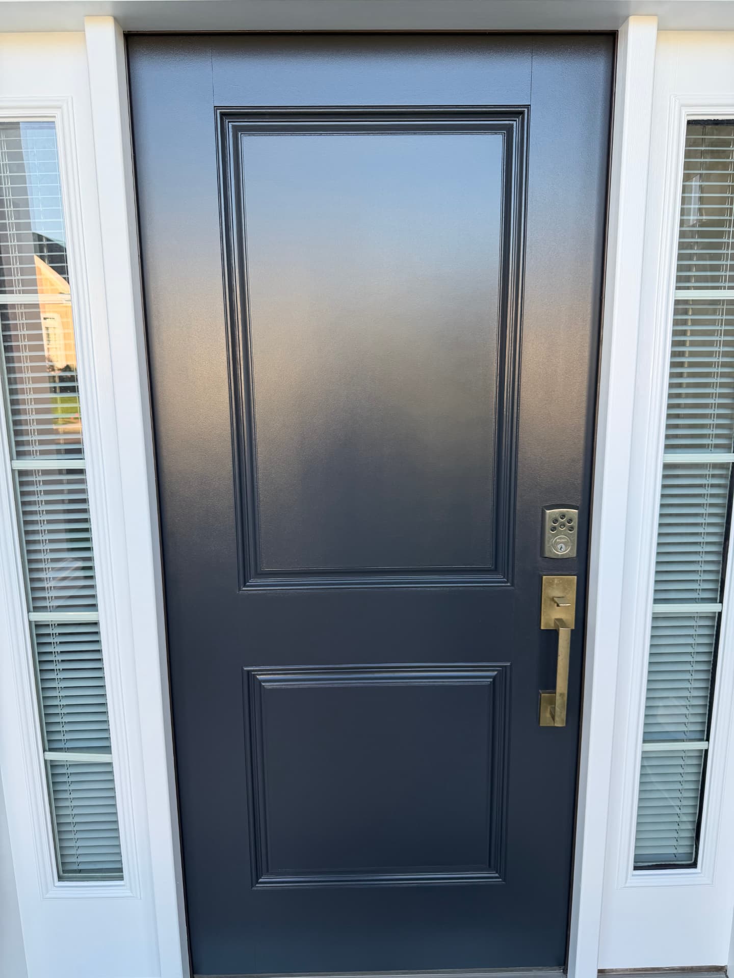Close-up of finished dark front door panels and brass hardware