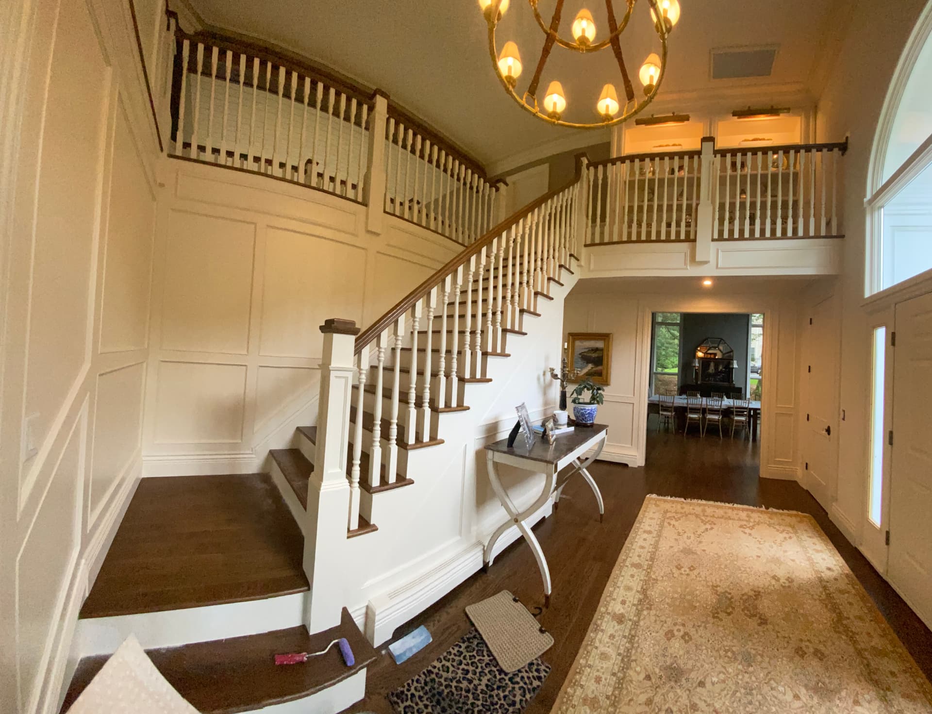 White painted staircase, wall paneling, and upper landing