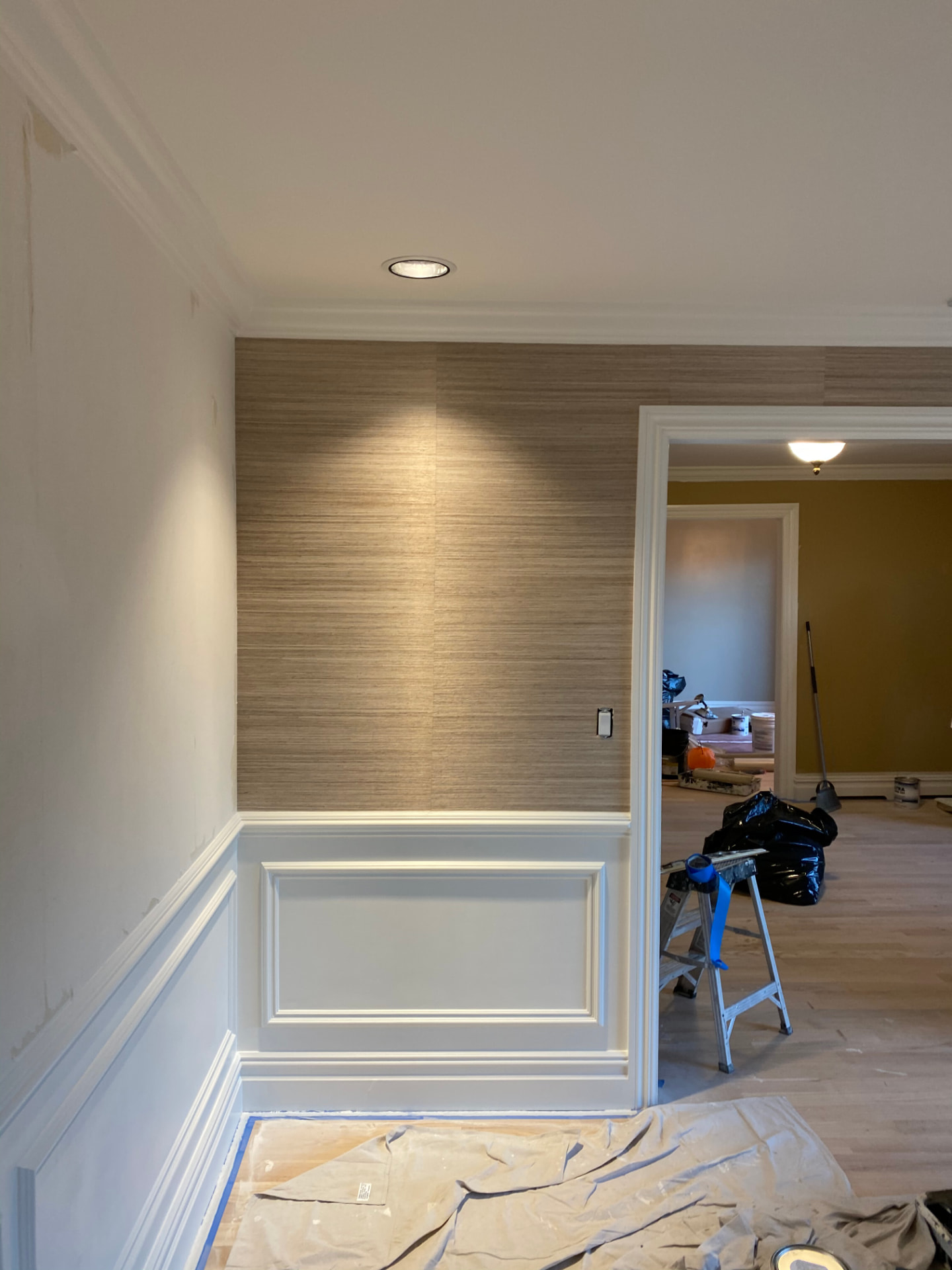 White wainscoting, doorway trim, and crown molding during interior finishing
