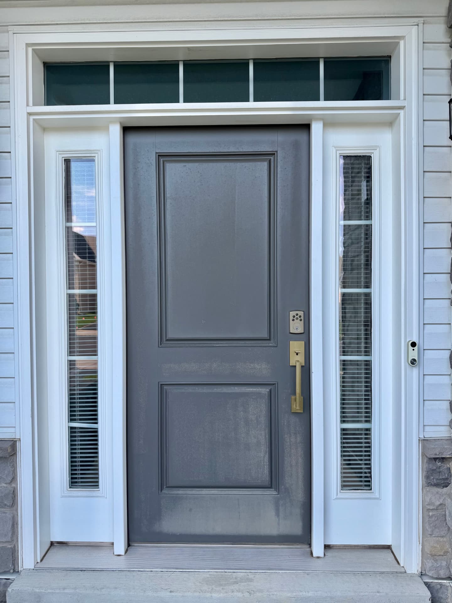 Weathered front door with white sidelights and transom before painting