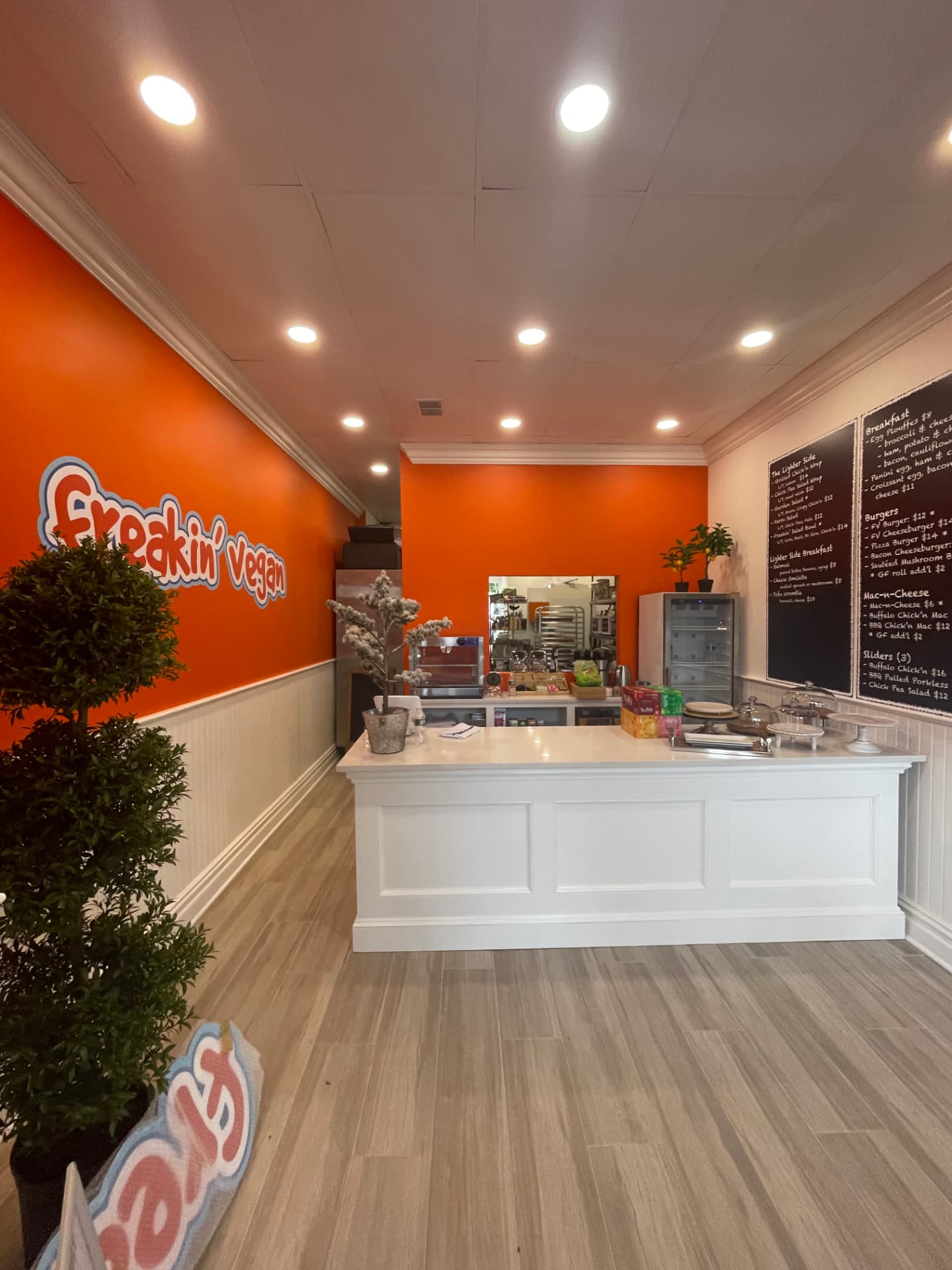 Restaurant interior with orange walls, white paneling, and painted counter