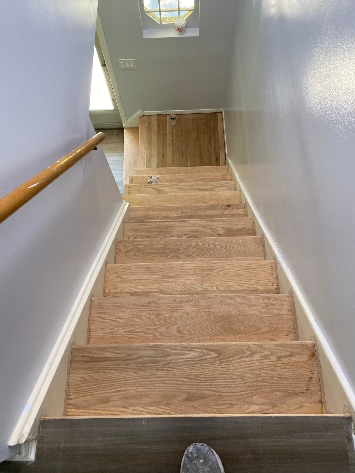 Stairway project with light walls and white baseboards beside unfinished wood steps