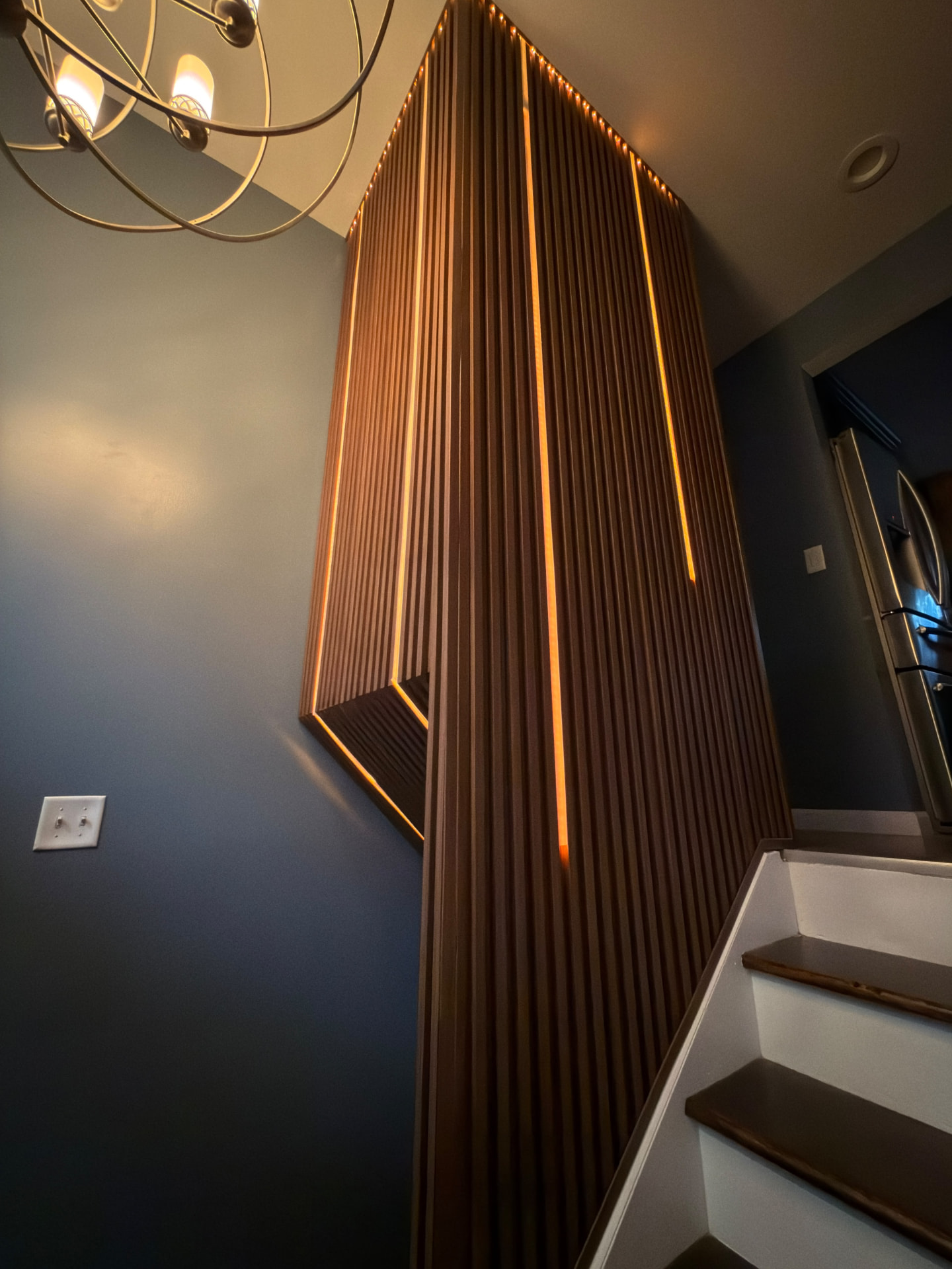 Painted stairway with illuminated wood accent wall